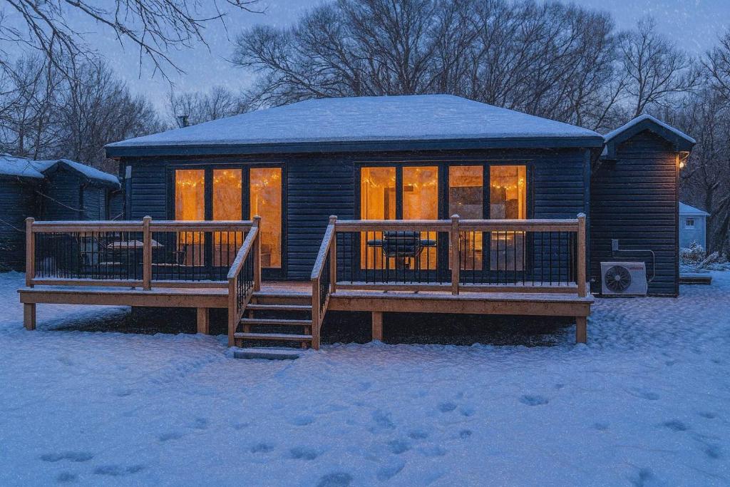 2-bedroom Lake Front Cottage in Harwood ON #4 في Harwood: كابينة خشبية مع سطح في الثلج