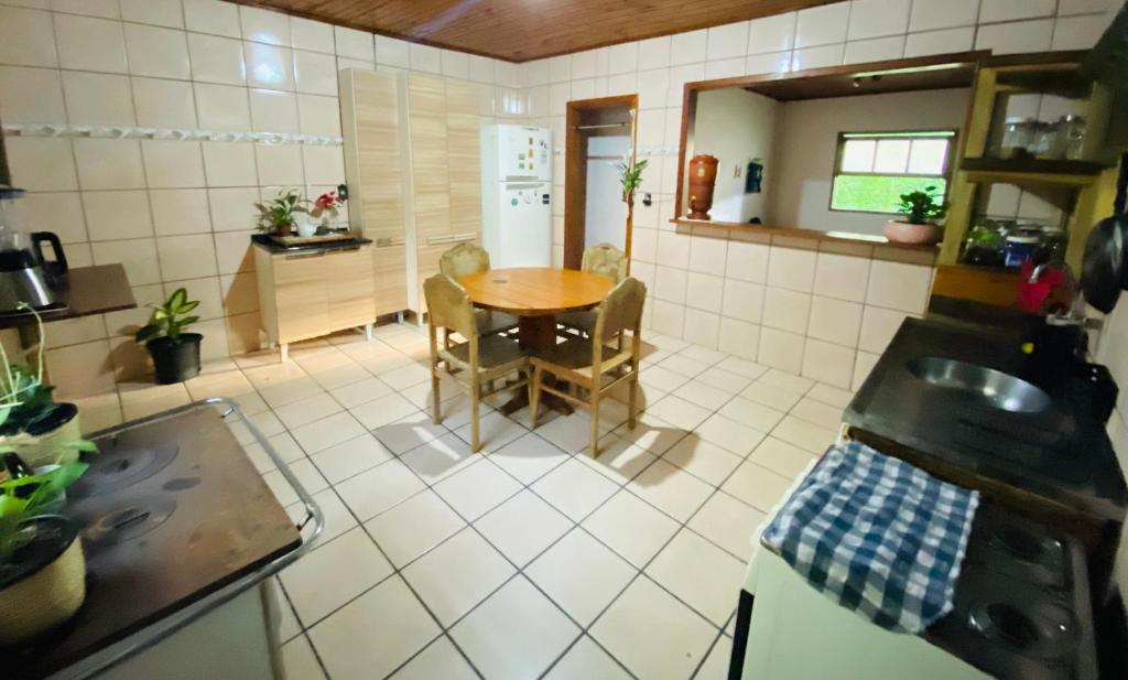 eine Küche mit einem Tisch und Stühlen in einer Küche in der Unterkunft Casa Canoa in Imbituba