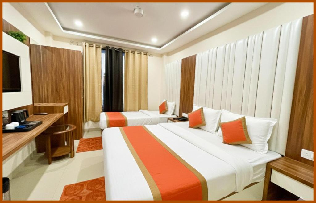 a hotel room with two beds and a desk at Hotel Shri RK Residency Near Kashi Vishwanath Temple - Fully Air Conditioning Rooms - Restaurant-Lift and Free Wifi Facilities- Top Rated Hotel In Varanasi in Kashi