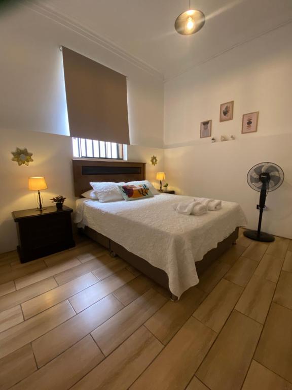 a bedroom with a large bed and a fan at Lince Apartments in Lima