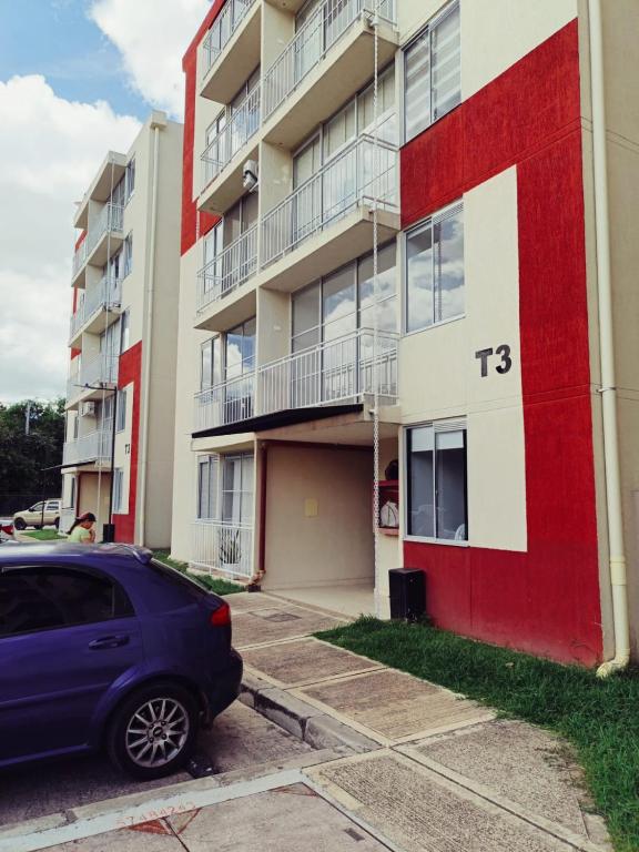 a blue car parked in front of a building at APARTAMENTO RICAURTE Cund in Ricaurte