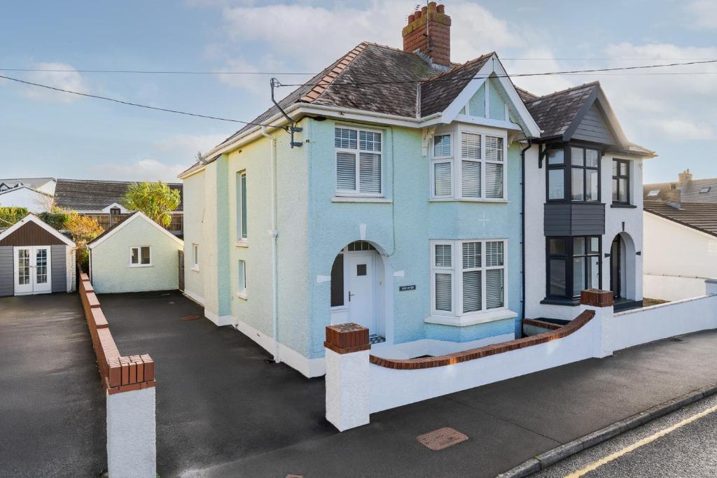 uma casa azul e branca com uma entrada em Arwerydd em Aberporth