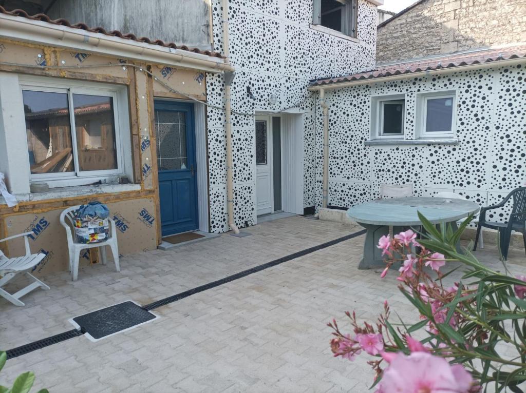un patio con porta blu, tavolo e sedie di La douce escale ad Angoulême