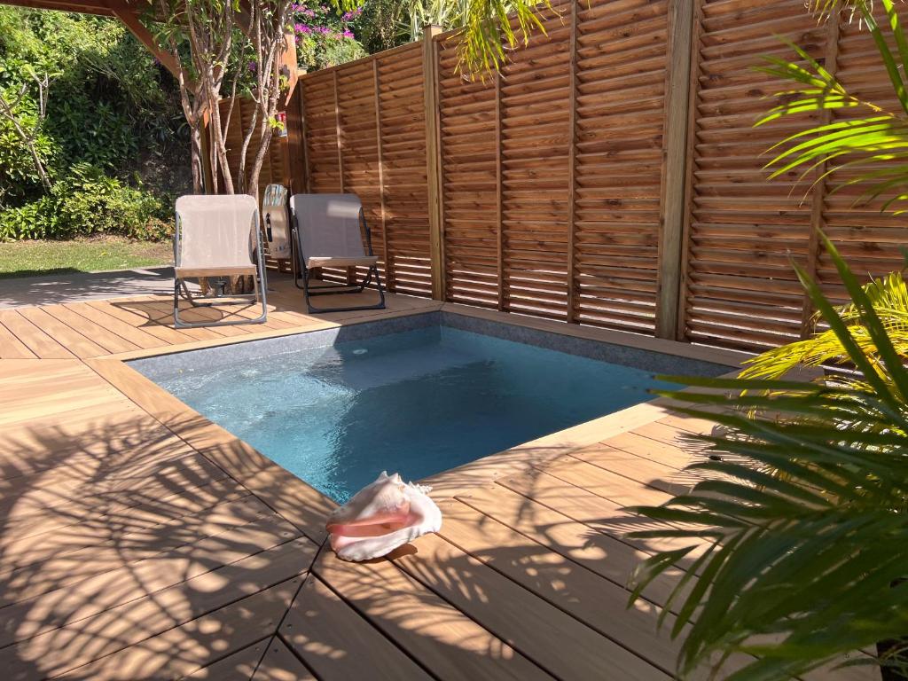 PomKalbas - Les lodges Racines é Zel في Vieux-Fort: مسبح صغير وبه كرسيين وسياج