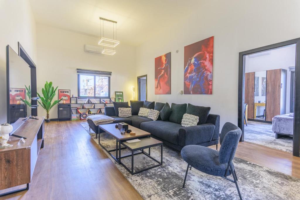 Residence 4 - Comfy Apts & Balconies in Mar Mikhael في Al Mudawwar: غرفة معيشة بها أريكة وطاولة