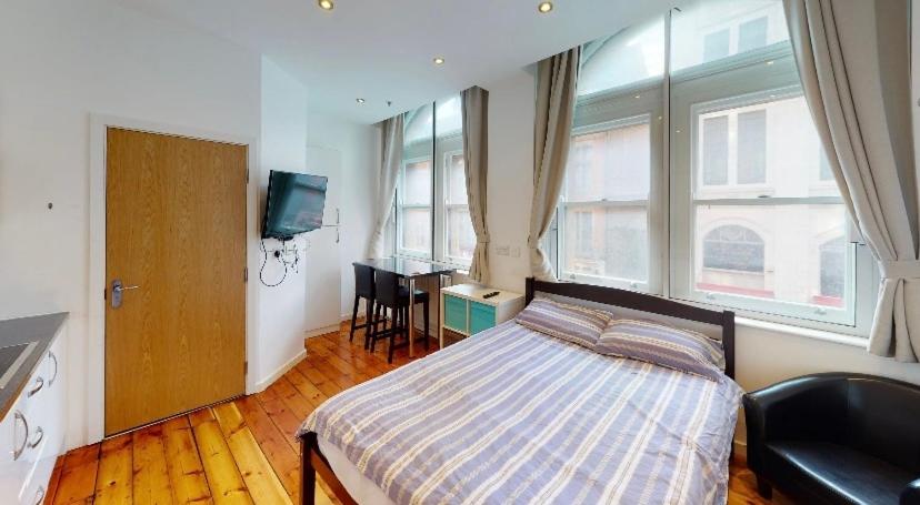 a bedroom with a bed and a desk in it at Modern Studio, 1st floor, King Street Views in Nottingham
