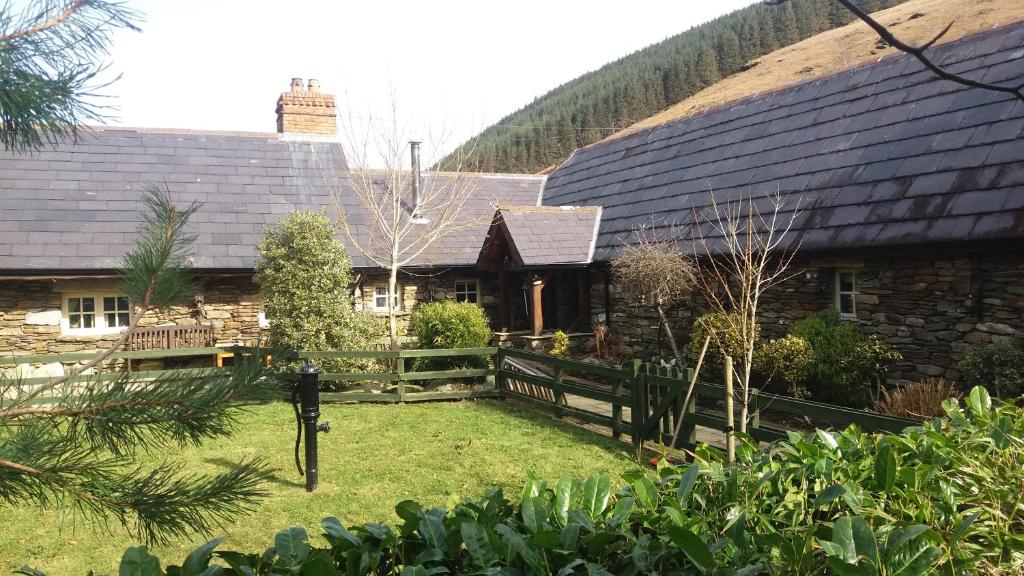 una casa con una valla de madera delante de ella en Clarisses Cottage, en Laragh