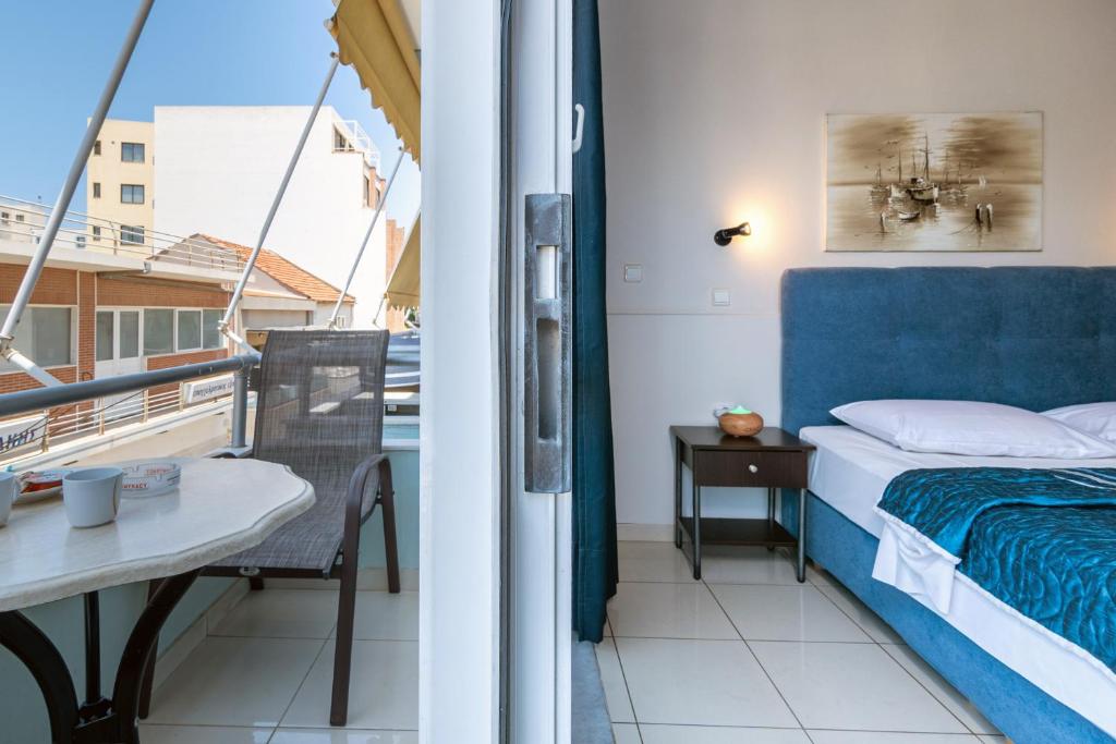 干尼亚阿伦娜公寓的一间卧室,阳台上配有一张床和一张桌子