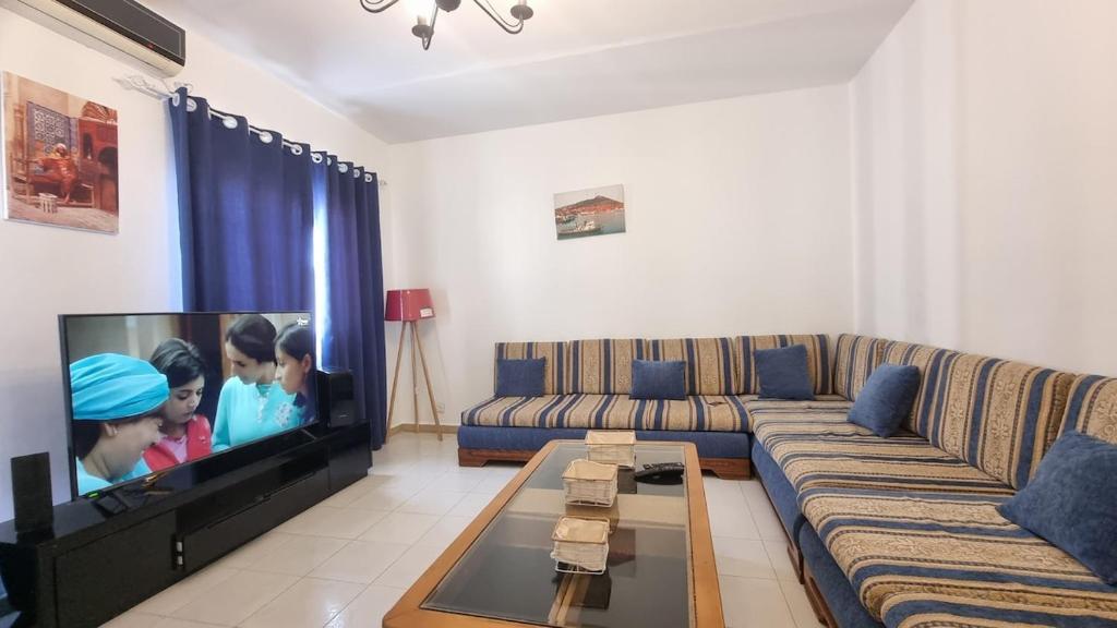 un soggiorno con divano e TV a schermo piatto di Confort & Soleil Akid Lotfi a Orano