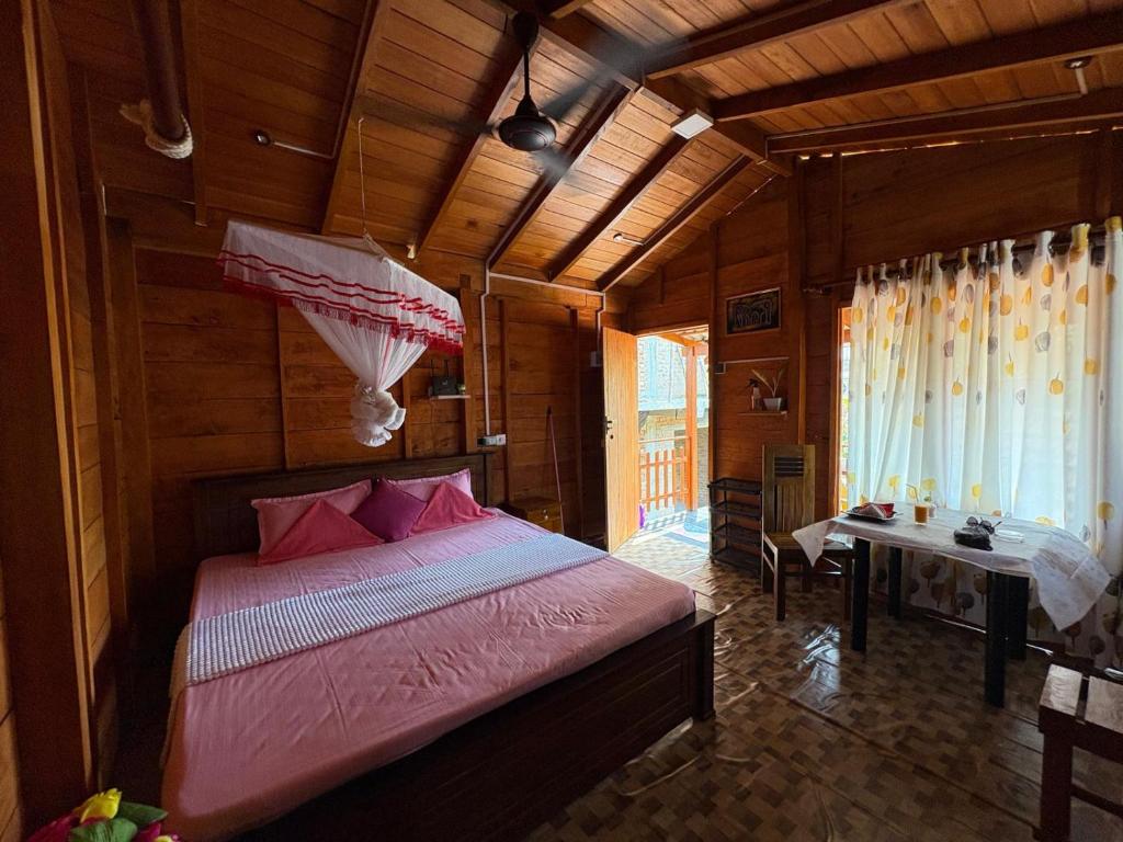 a bedroom with a bed and a table in a room at Wooden House Mirissa in Mirissa