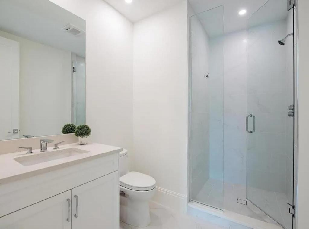 a bathroom with a shower and a toilet and a sink at Stylish Downtown Naples Retreat in Naples