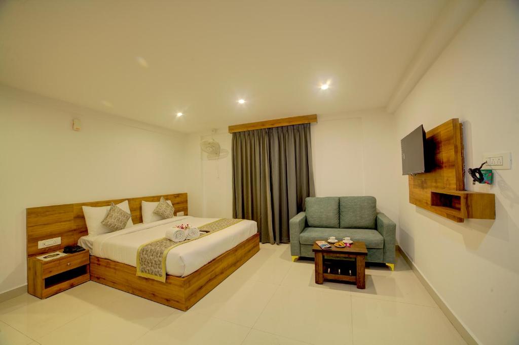 a hotel room with a bed and a chair at Fly Inn Bangalore Airport in Muthugadahalli