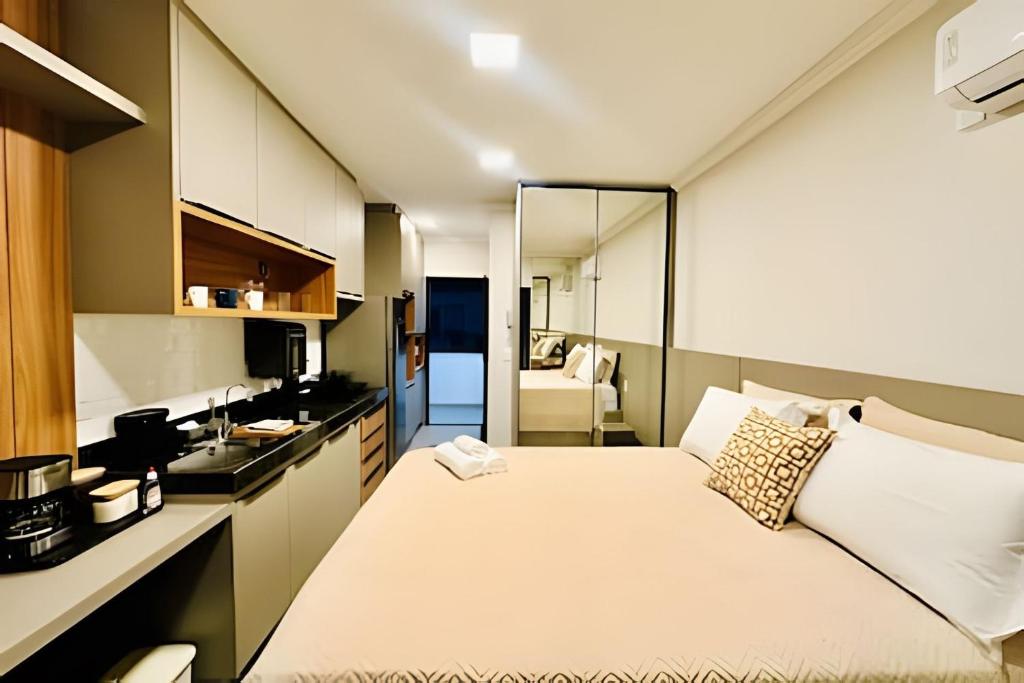 a small room with a bed and a kitchen at Studio Citrino – Localização perfeita próx. da Ufu in Uberlândia