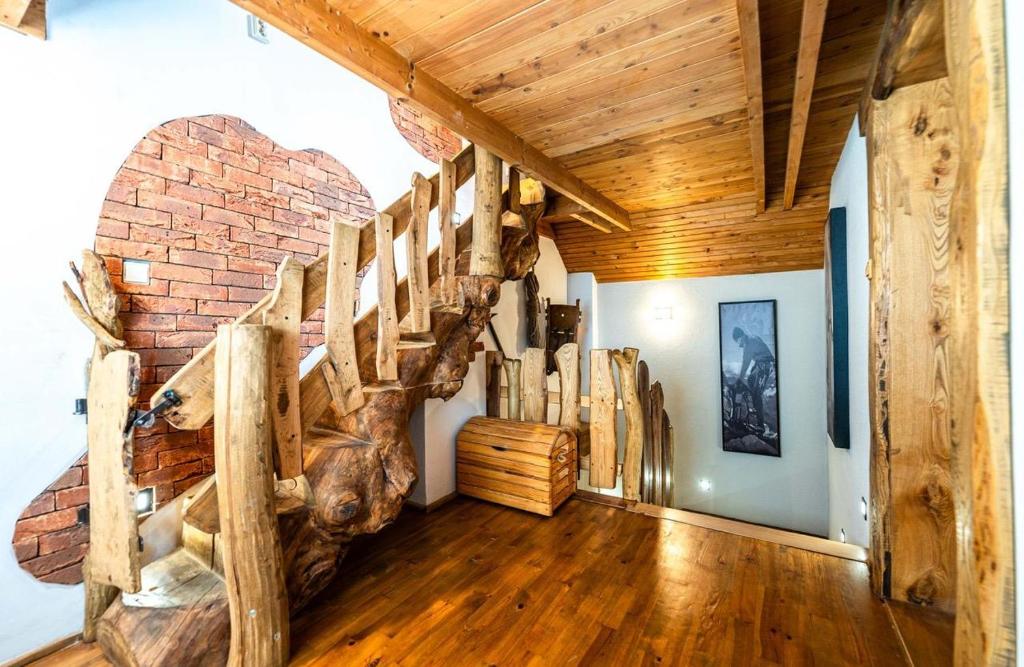 a living room with a wooden staircase in a house at Apartman Kamzik - 2 in Veľká Lomnica
