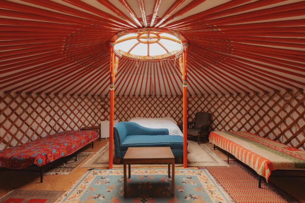 a room with two beds and a table in a yurt at Cosy yurt at a nature retreat in CA in Miramonte