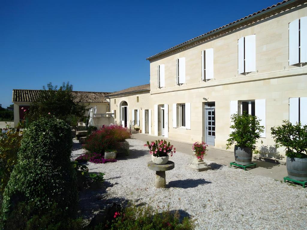 a building with a courtyard with potted plants in front of it at Chambre d'Hotes La Roseraie in Parsac