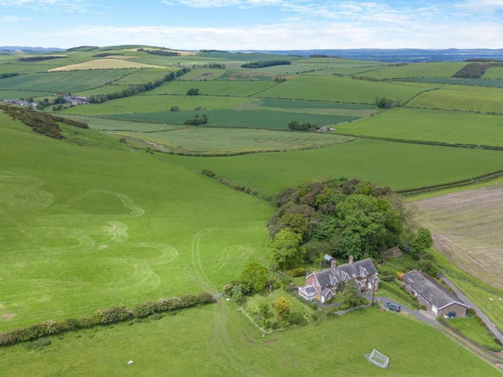 an aerial view of a house in a green field at 2 Bed in Mindrum oc-50973 in Crookham