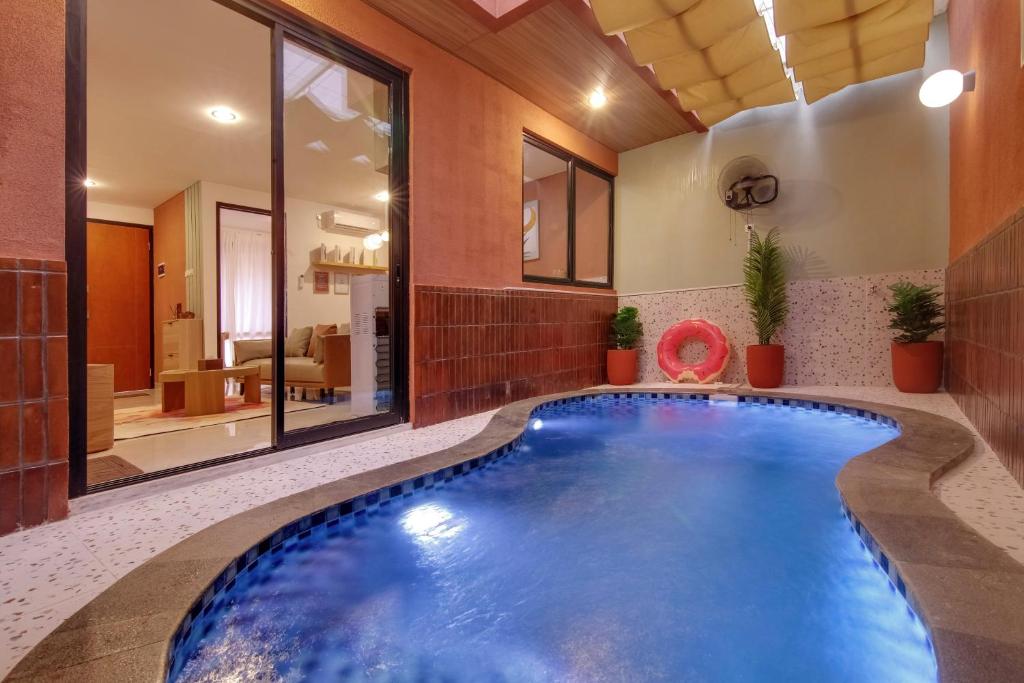 an indoor pool in a house with a large room with a swimming pool at Trevista With Private Pool in Curug 1