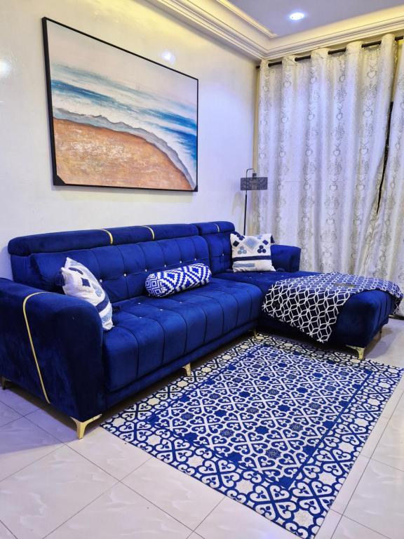 a blue couch in a living room with a rug at Studio idéal pour vos sejours in Dakar