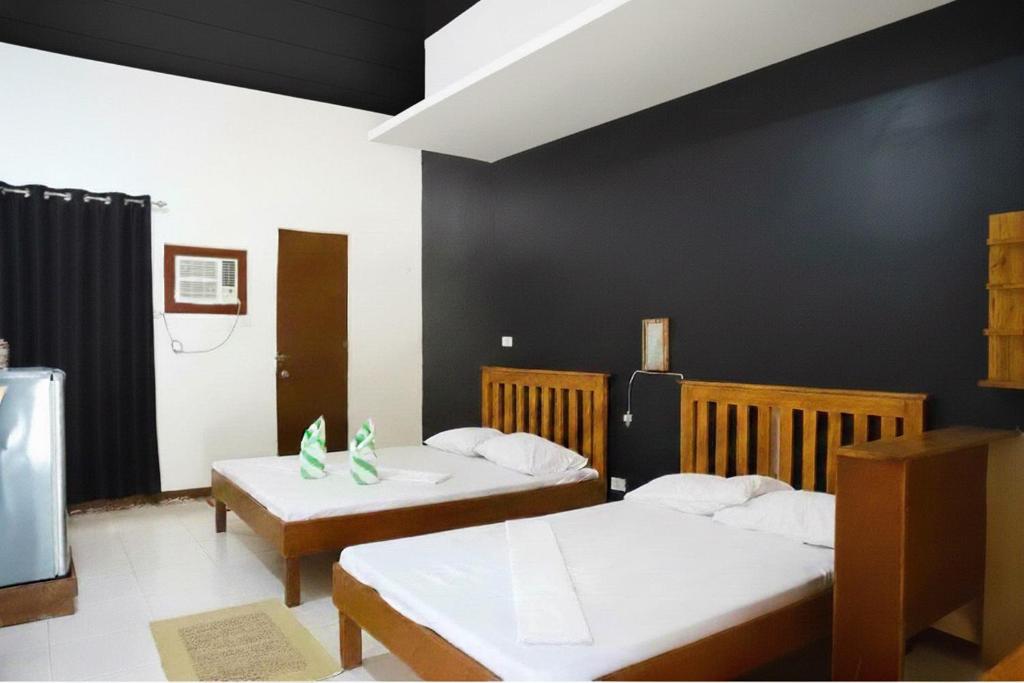 una camera con due letti e una parete nera di D Mountain Beach Resort a Puerto Galera