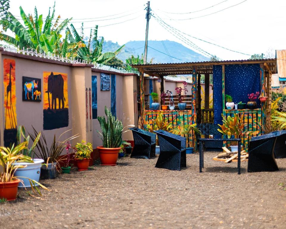 a group of chairs and plants in front of a building at Mango Hostel Arusha in Arusha