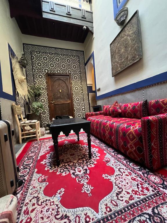 a living room with a red couch and a red rug at Riad Mamma MARRAKESH in Marrakech