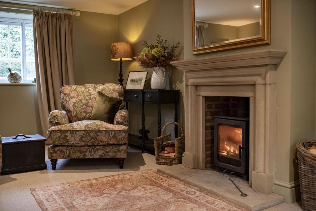 a living room with a chair and a fireplace at Lark Rise in Boltby