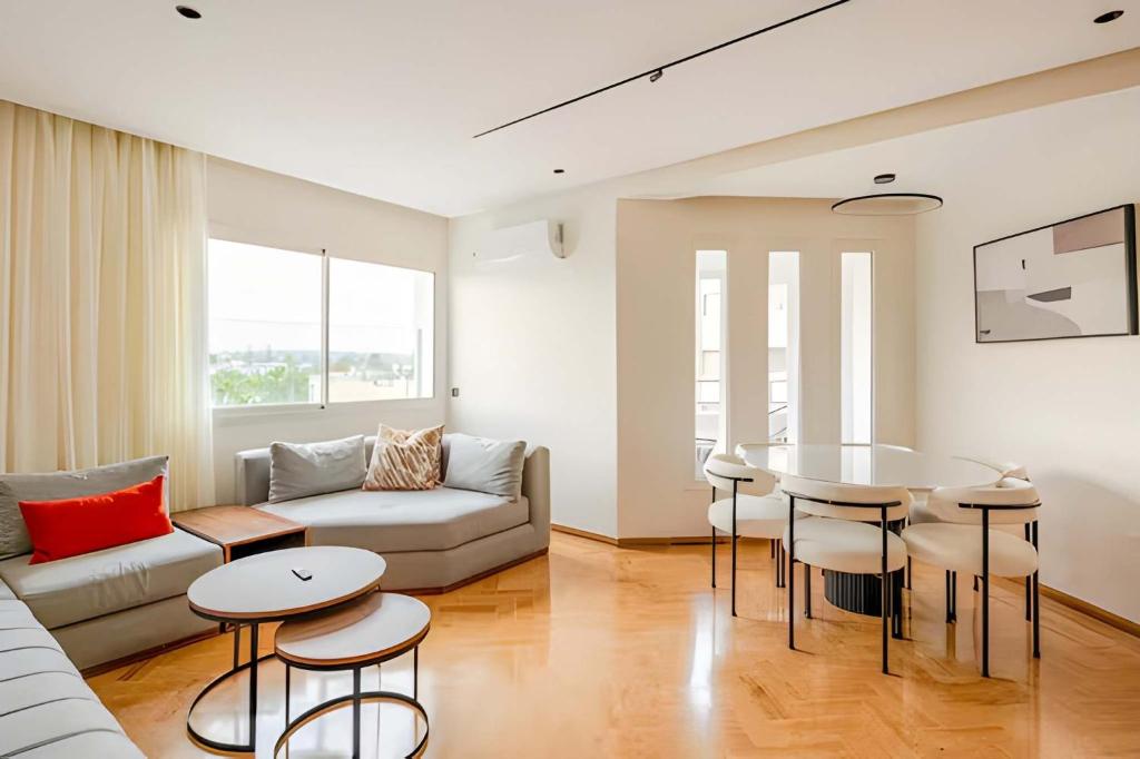 een woonkamer met een bank en een tafel bij Luxury Central 3BR 5min from Beach & Shopping in Casablanca