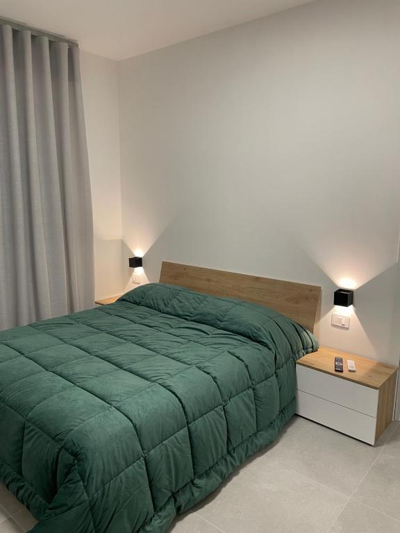 Una cama con un edredón verde en un dormitorio. en Urban Travelers Apartments, en Isernia