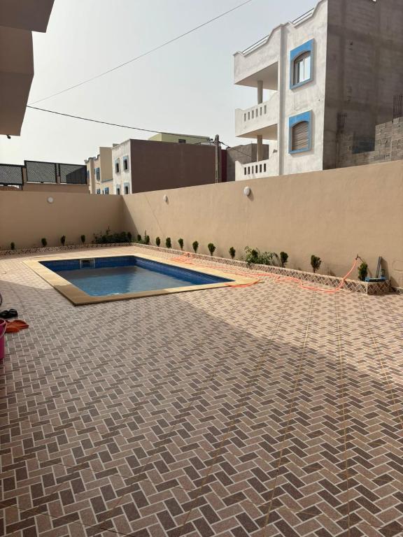 a swimming pool in front of a building at Ber appartement in Mirleft