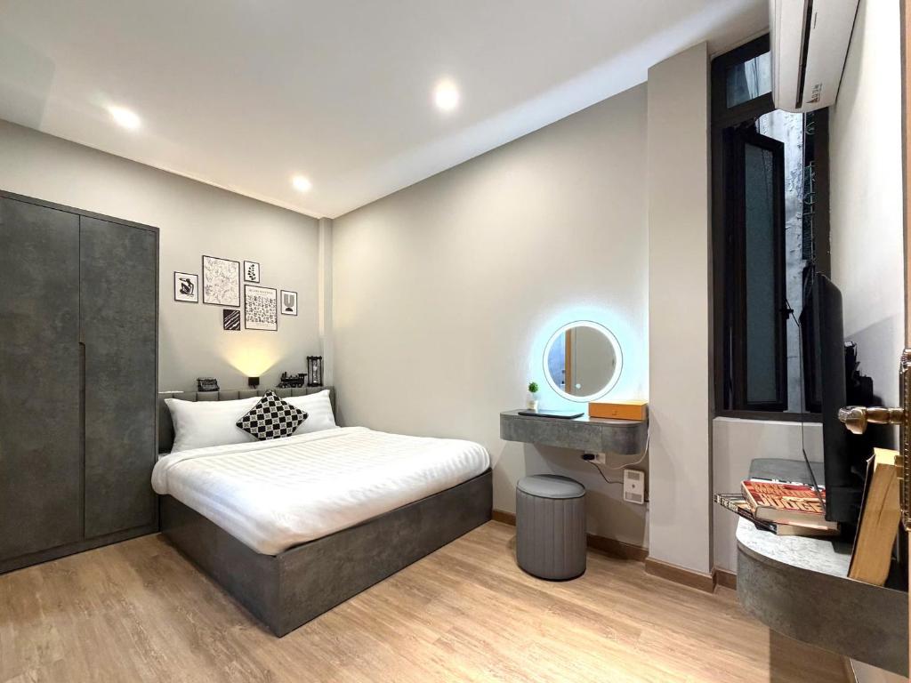 um quarto com uma cama, uma pia e um espelho em The Indochina Homestay and Travel by Nguyen em Hanói