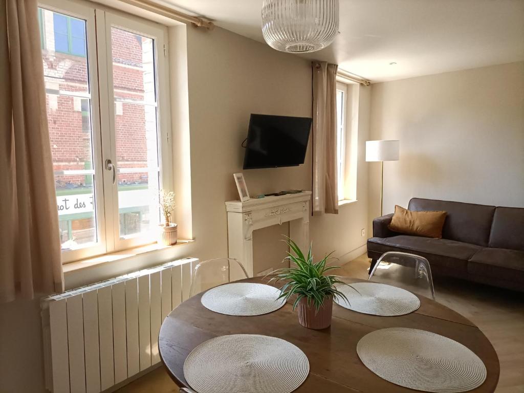een woonkamer met 2 tafels en een bank bij Les Roses - Appartement cosy proche plage - Veules-les-Roses in Veules-les-Roses