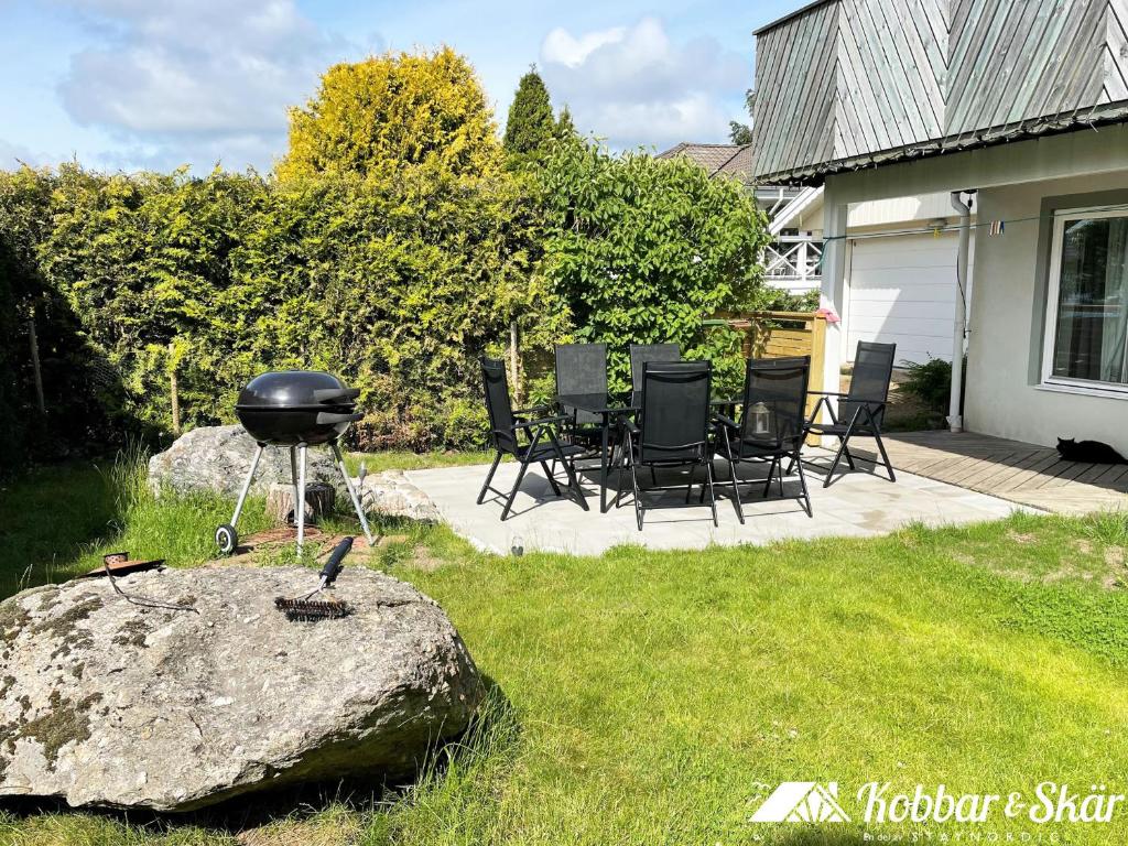 Lovely apartment, perfect for exploring Tjörn and Orust SE09153 في Varekil: شواية فحم موضوعة على صخرة في فناء منزل