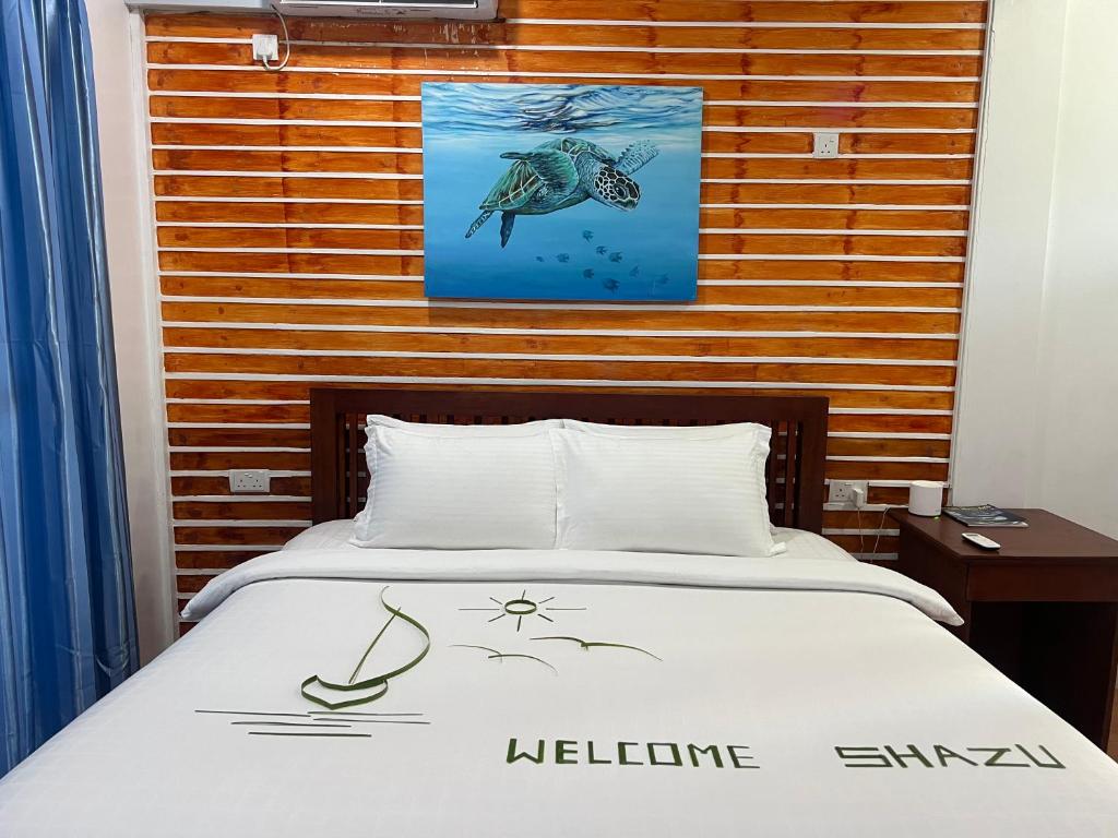 Nautical Nook Maldives في Kendhoo: غرفة نوم بها سرير وصورة على الحائط