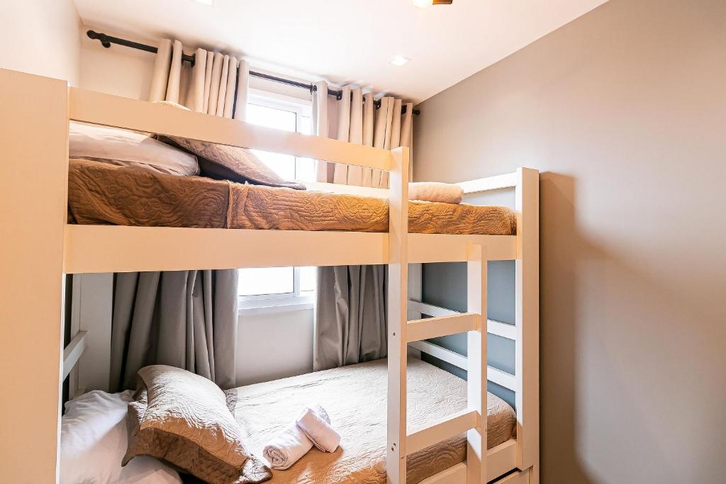a bunk bed room with two bunk beds and a window at Apto Completo para 6 Hóspedes • Brás, SP in Sao Paulo