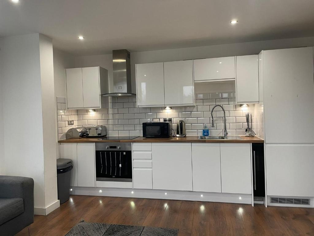 een keuken met witte kasten en een aanrechtblad bij Forest Gate Nest Nottingham in Nottingham