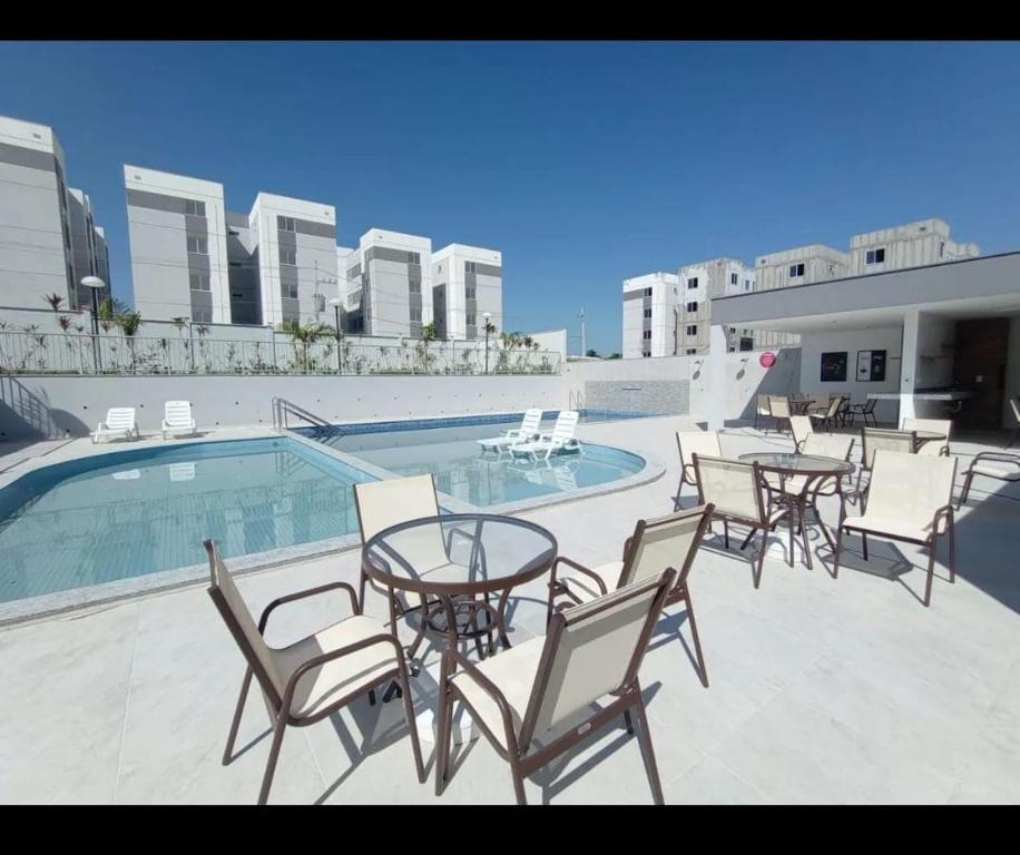 マナウスにあるsmart torquatoのスイミングプールの隣にテーブルと椅子付きのパティオ