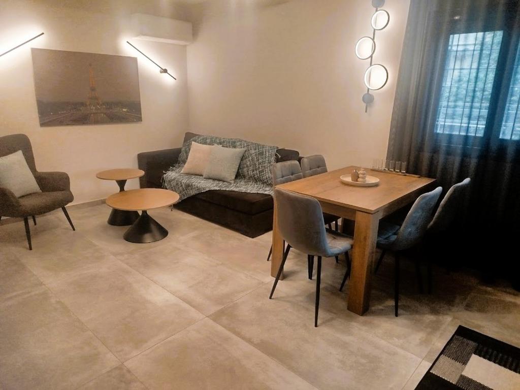 un salon avec un canapé, une table et des chaises dans l'établissement Frank and Jimmy apartments, à Tríkala