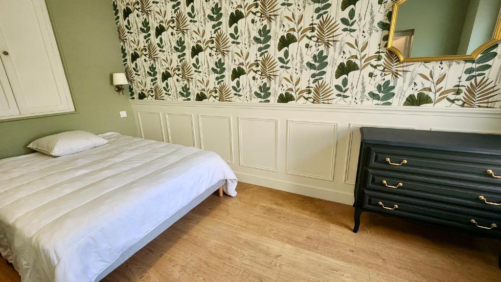 Le Moulin - Appartement cosy proche plage - Veules-les-Roses في فول-لي-روز: غرفة نوم بسرير ومرآة وخزانة