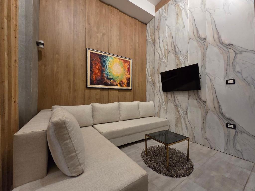 Colombia Apartments&Rooms في دوريس: غرفة معيشة مع أريكة وتلفزيون