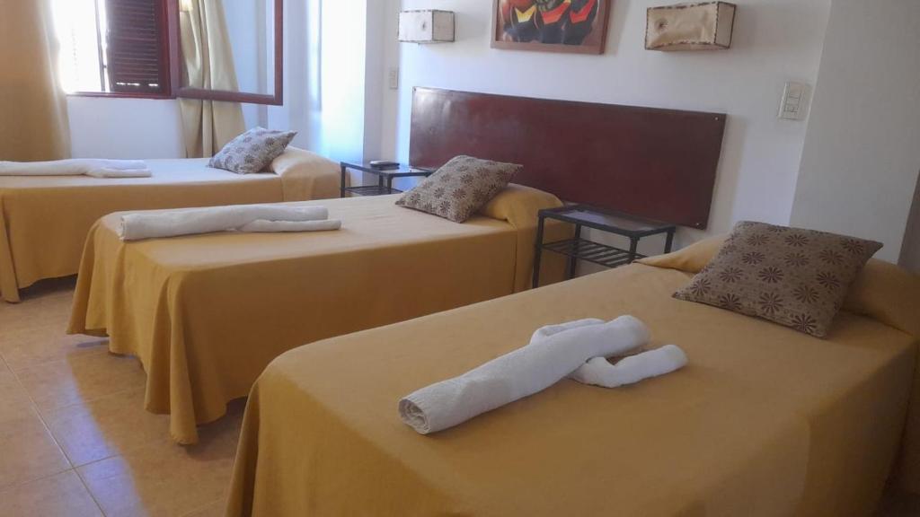Habitación con 3 camas con sábanas amarillas. en Toneles - Cafayate, en Cafayate