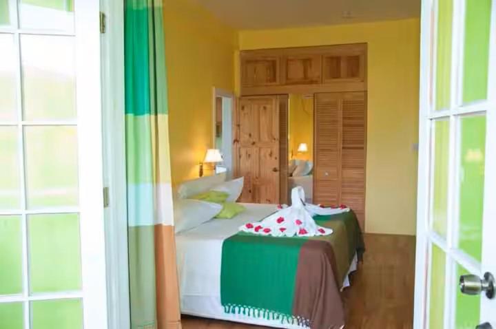 a bedroom with a bed with a cake on it at Diamond View Cottages in Roseau