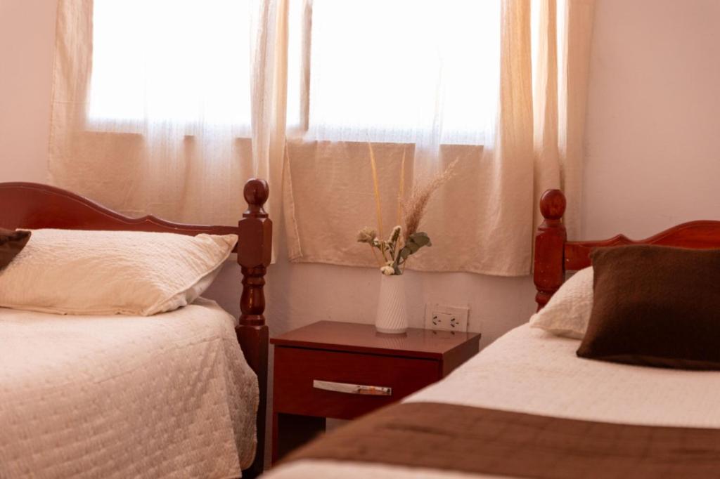 ein Schlafzimmer mit zwei Betten und einem Fenster in der Unterkunft Hostal el rincón de cusi in Mina Pirquitas