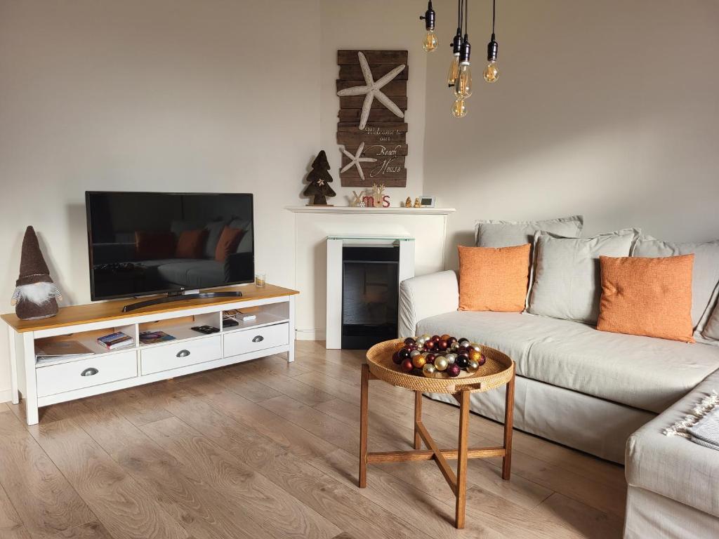 Bonair Gezellig appartement in hartje Wenduine في فينداوني: غرفة معيشة مع أريكة وتلفزيون