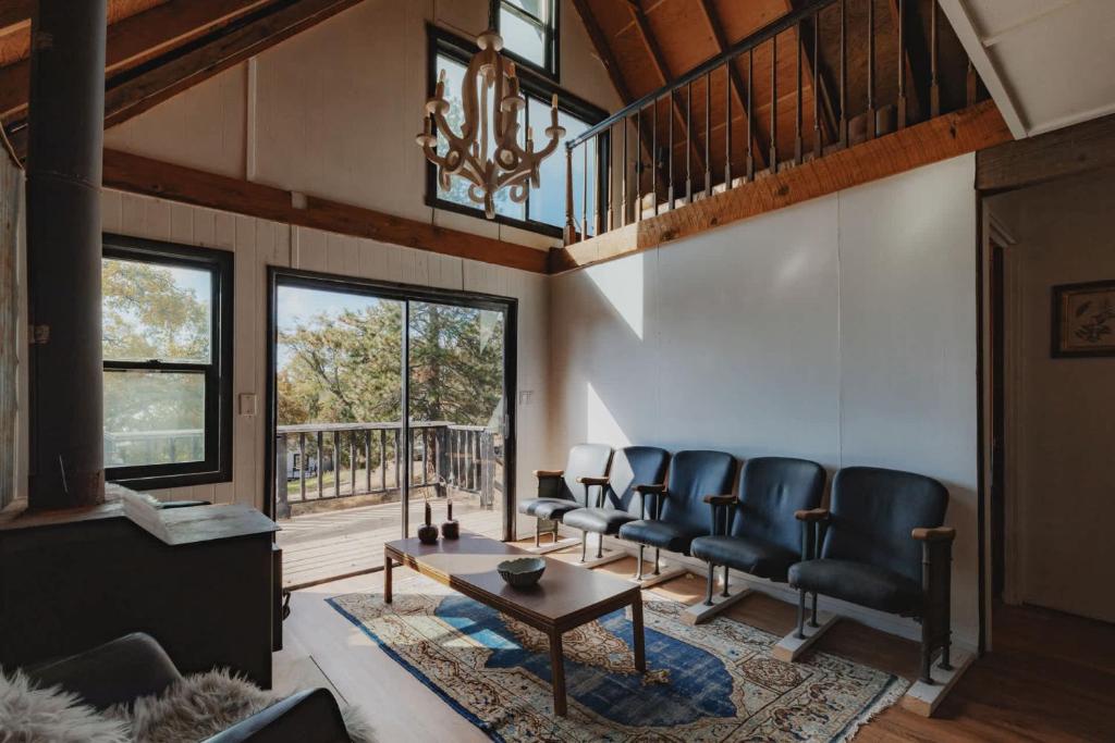 a living room with leather chairs and a table at Secluded rustic 3-bedroom cabin on private land in Miramonte