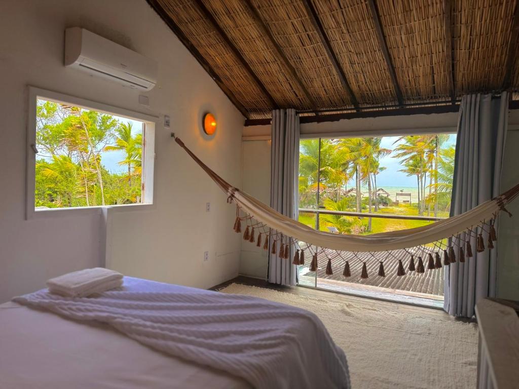 1 dormitorio con hamaca frente a una ventana en Kokar Casa Hotel - Santo André, en Santa Cruz Cabrália