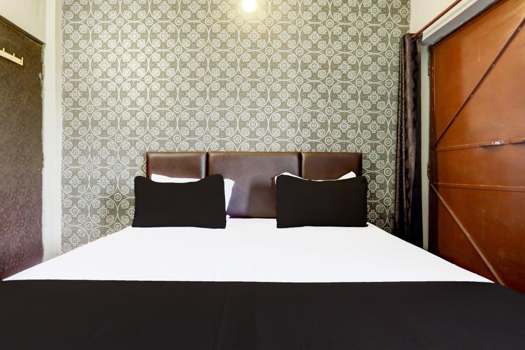 Un dormitorio con una cama con dos almohadas encima. en Hotel O Rewansh in, en Bhilai