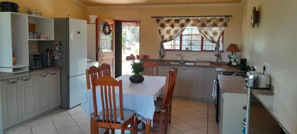 una cucina con tavolo e sedie e una cucina con frigorifero di Wilderness Phoenix Rising a Wildernis