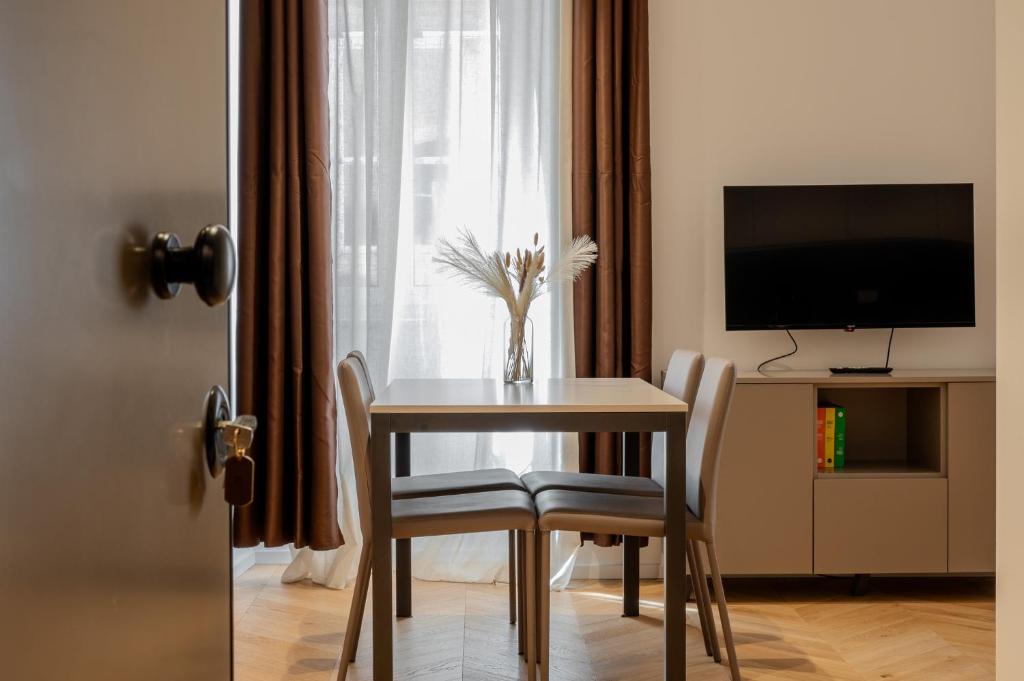 mesa de comedor y sillas con ventana en Palazzo Machiavelli Trieste, en Trieste