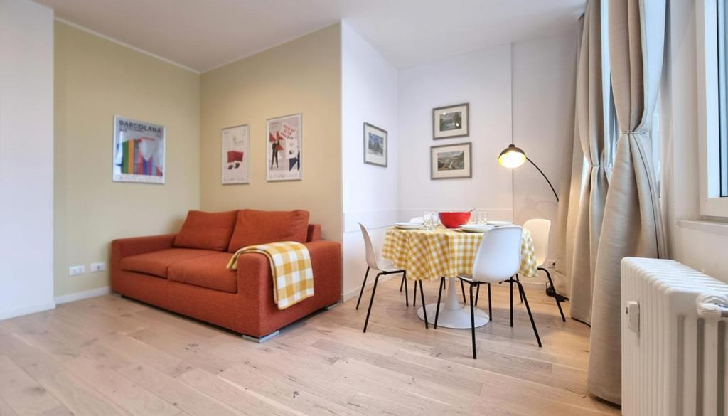 un soggiorno con un divano, un tavolo e delle sedie di Campo Marzio 6 a Trieste